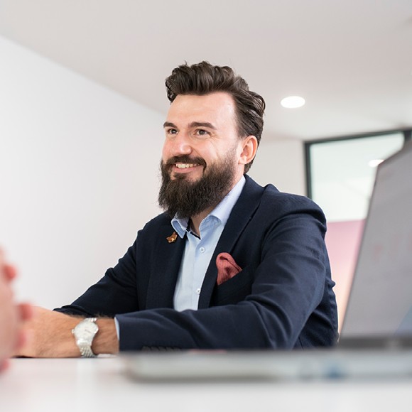 Porträt von Mitarbeitendem mit Laptop